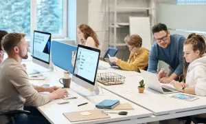 Ludzie pracujący przy komputerach w nowoczesnym biurze.