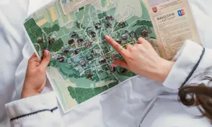 Kobieta w szlafroku przegląda mapę Nałęczowa z zaznaczonymi atrakcjami.
