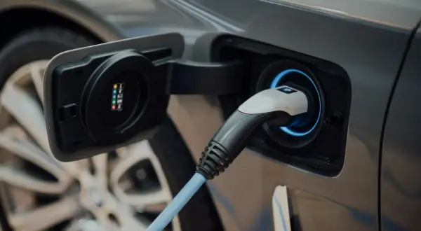 Wtyczka ładowania podłączona do samochodu elektrycznego.
