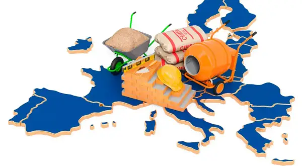 Mapa Europy z materiałami budowlanymi: cement, betoniarka, taczka, cegły, kask.