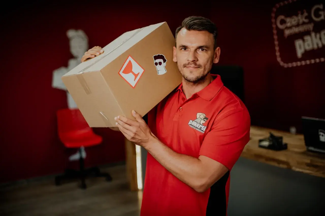 Kurier DPD z paczką na ramieniu. Zastanawiasz się, ile zarabia kurier DPD? Ten pracownik wygląda na zadowolonego z pracy.