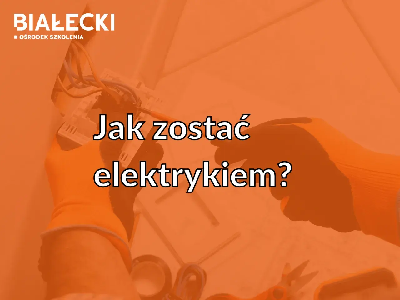 Ręce w pomarańczowych rękawicach podłączają przewody elektryczne.
