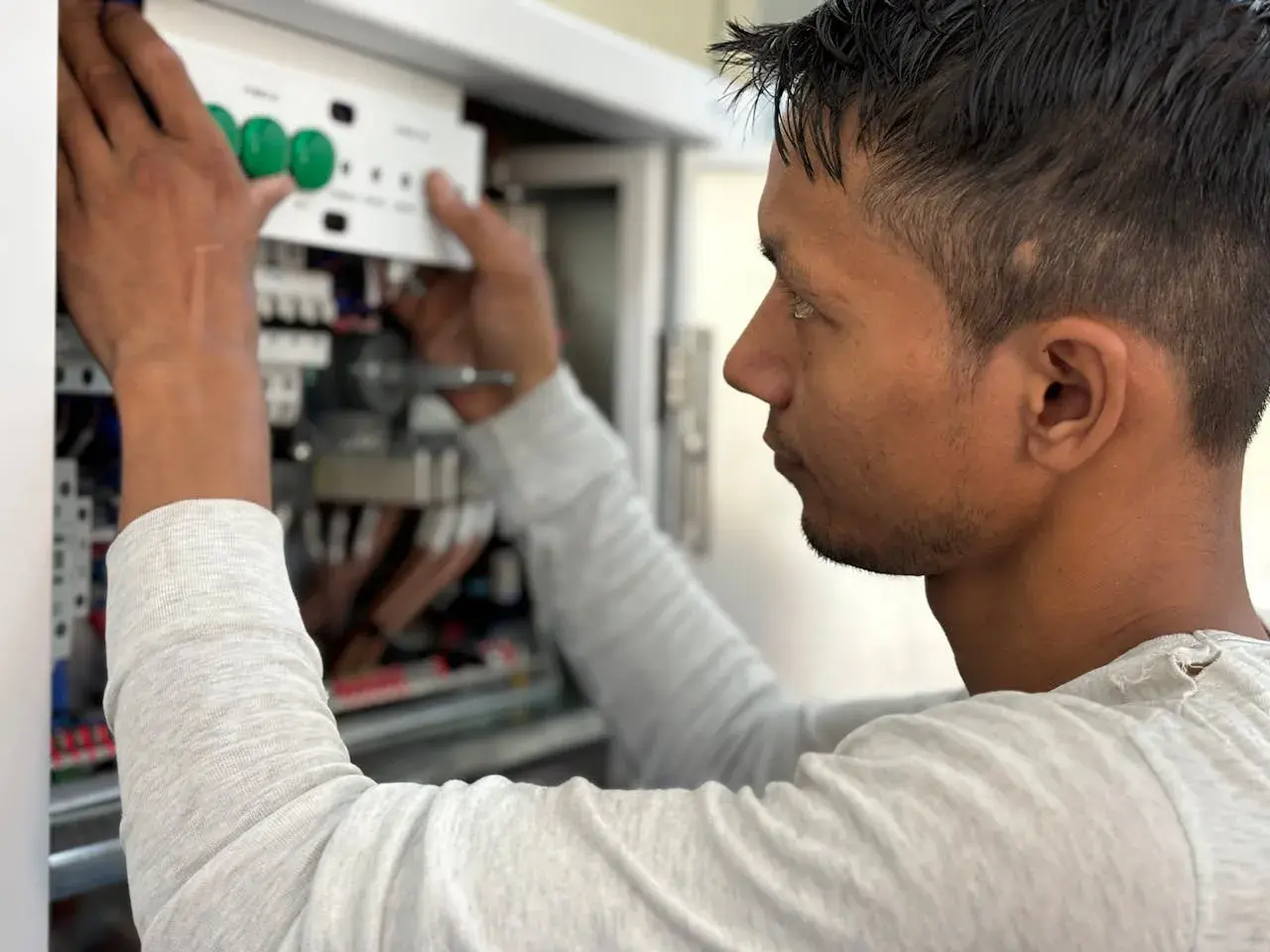 Elektryk montuje panel sterowania w skrzynce elektrycznej.