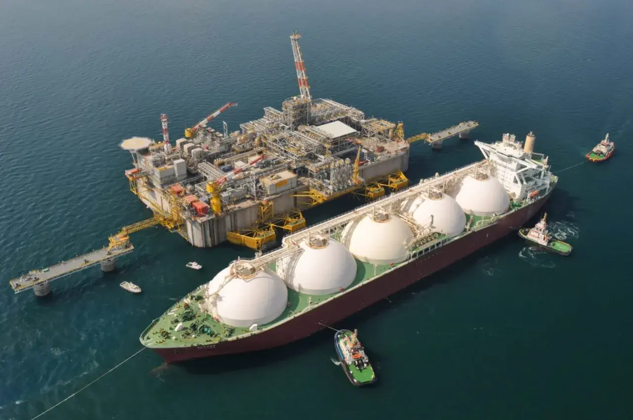 Statek LNG przy platformie wiertniczej, holowniki na morzu.
