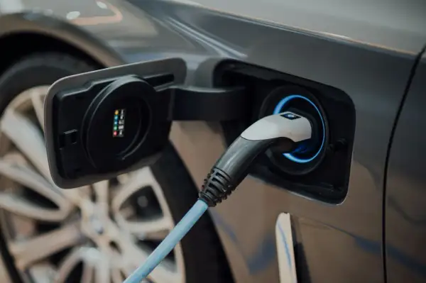Wtyczka ładowania podłączona do samochodu elektrycznego.