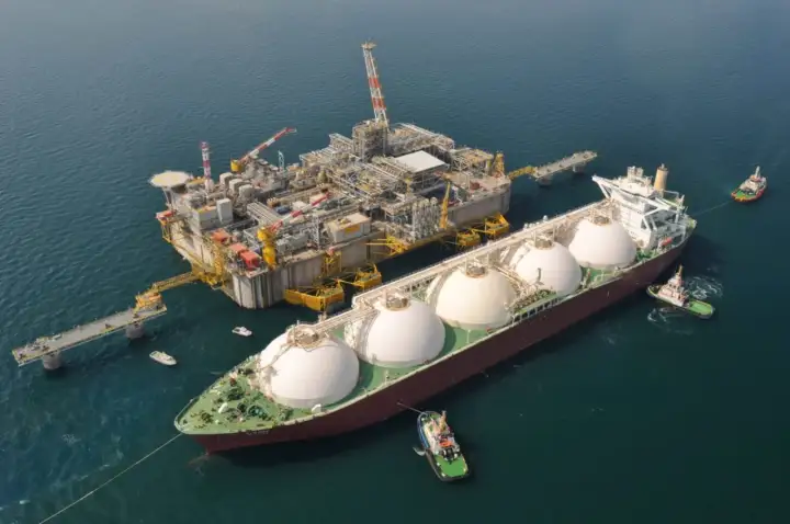 Statek LNG przy platformie wiertniczej, holowniki na morzu.